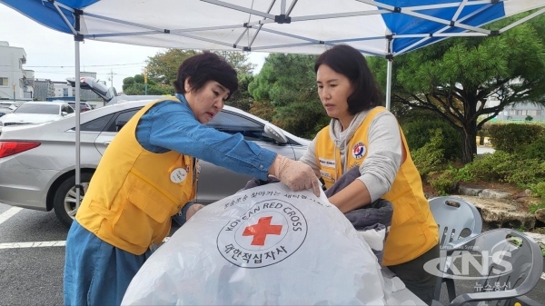 봉사원들이 건조된 이불을 취약계층 이웃에게 전달하기 위해 비닐팩에 넣고 있다  사진=경북적십자사